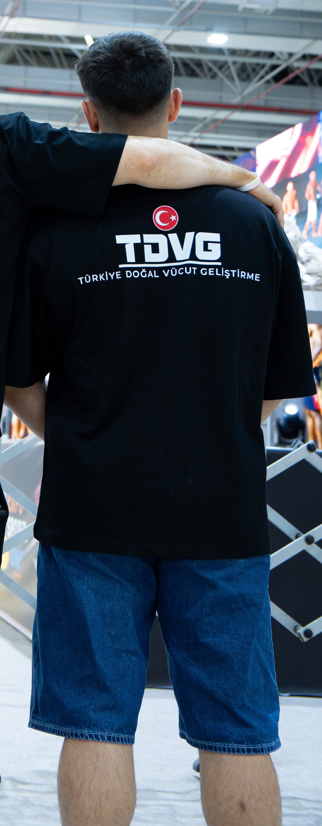 DOĞAL. 002 × TDVG tişört — gerçek etkinlik fotoğrafı, orijinal TDVG sırt baskısı